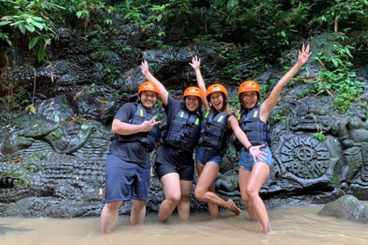 Guests cheering in a red raft on the Ayung River rapids
