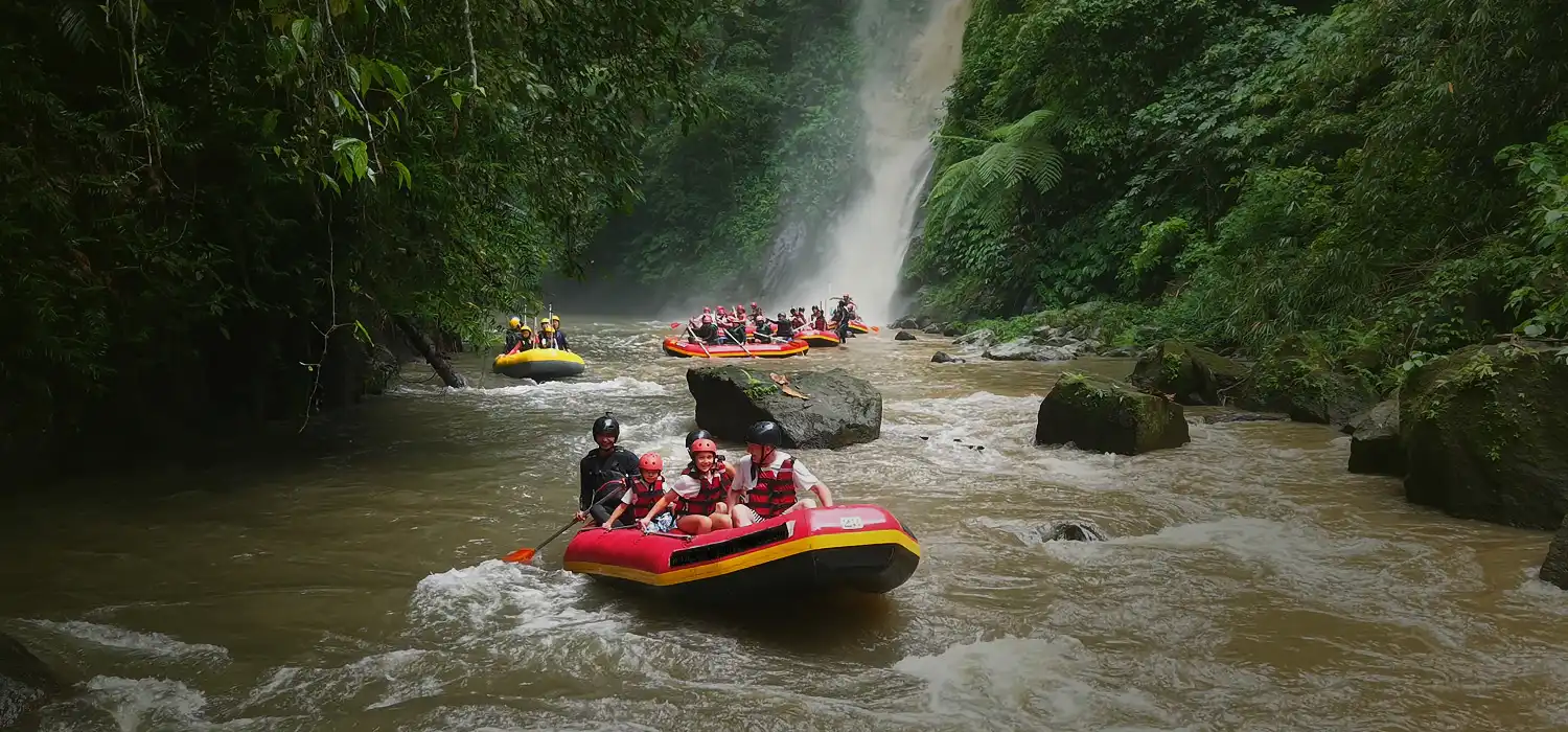 Rafting on the Ayung River in Ubud, Bali with a waterfall in the background